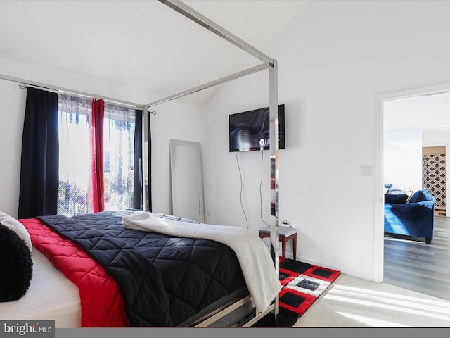 bedroom featuring wood-type flooring and vaulted ceiling