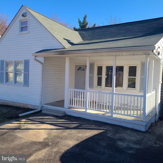 view of front of home with a porch and a shingled roof