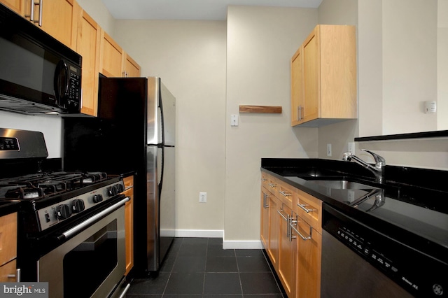 kitchen with light brown cabinets, dark tile patterned floors, sink, and appliances with stainless steel finishes