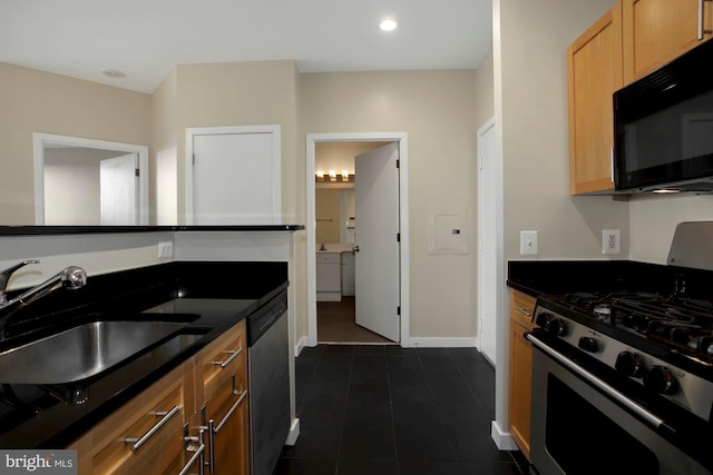 kitchen featuring appliances with stainless steel finishes, dark tile patterned floors, and sink