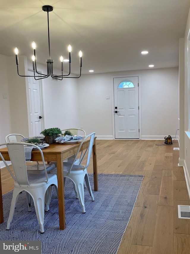 dining room featuring light hardwood / wood-style flooring and an inviting chandelier