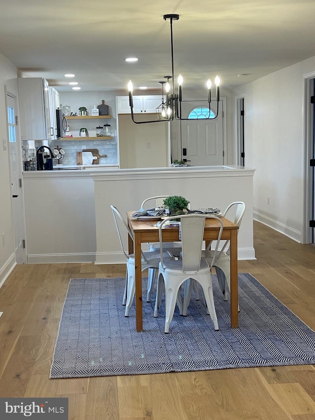 unfurnished dining area with a chandelier and light hardwood / wood-style floors