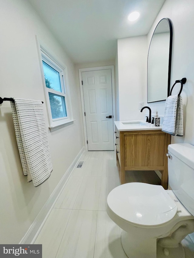 bathroom featuring tile patterned flooring, vanity, and toilet