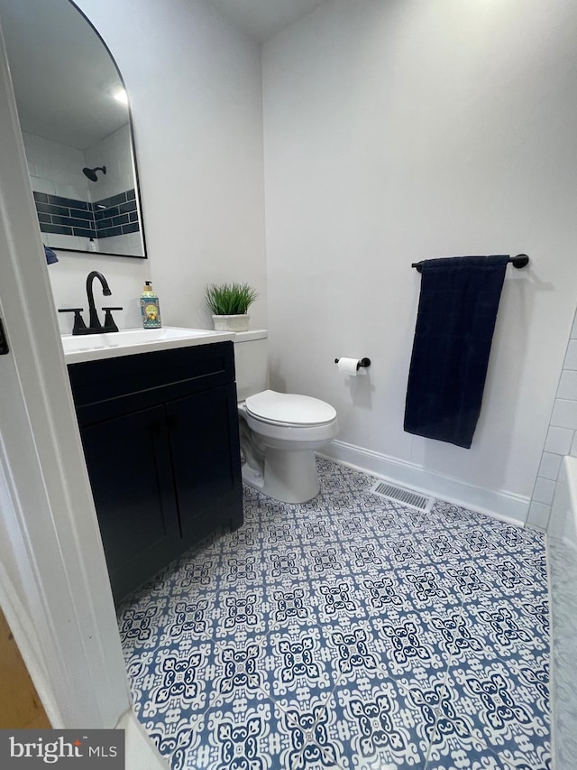 bathroom featuring a shower, vanity, and toilet