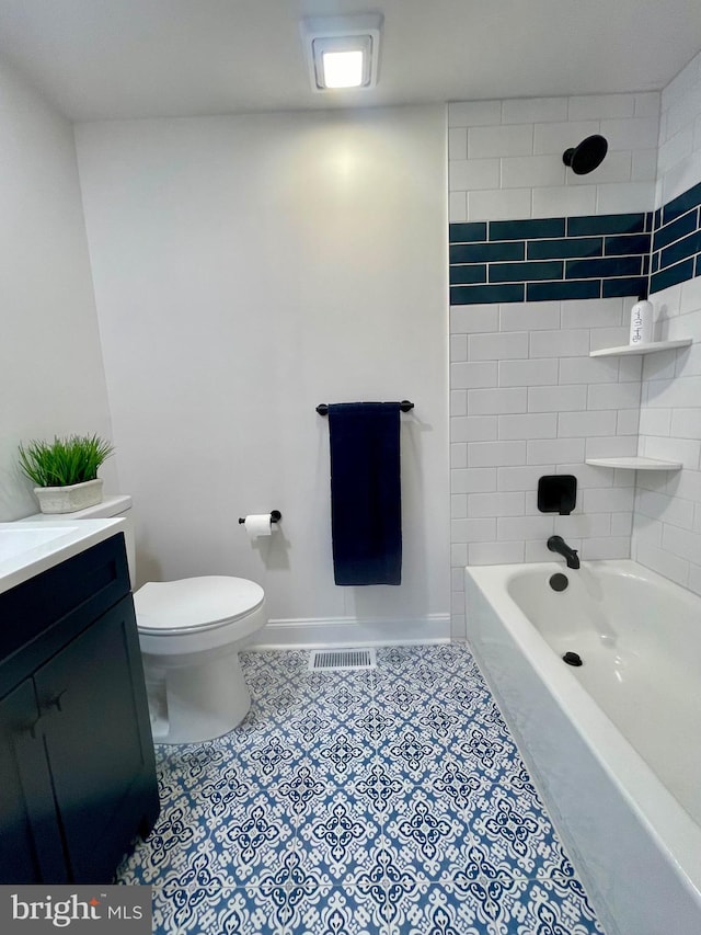 full bathroom featuring vanity, tiled shower / bath combo, and toilet