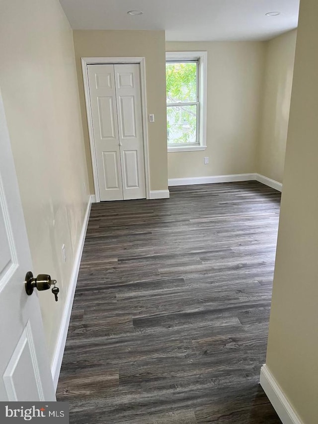 unfurnished bedroom featuring dark hardwood / wood-style floors and a closet