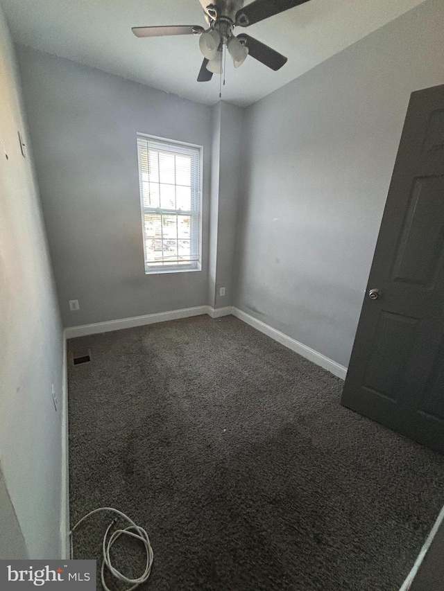 unfurnished room featuring ceiling fan and dark carpet