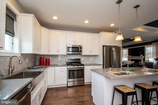 kitchen featuring white cabinets, decorative light fixtures, and stainless steel appliances