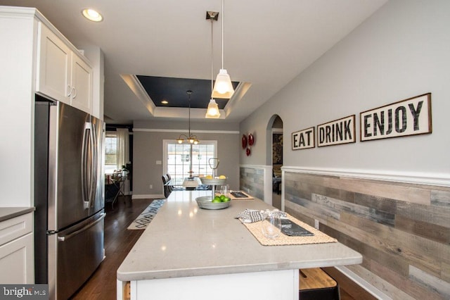 kitchen with pendant lighting, a center island, white cabinetry, and stainless steel refrigerator