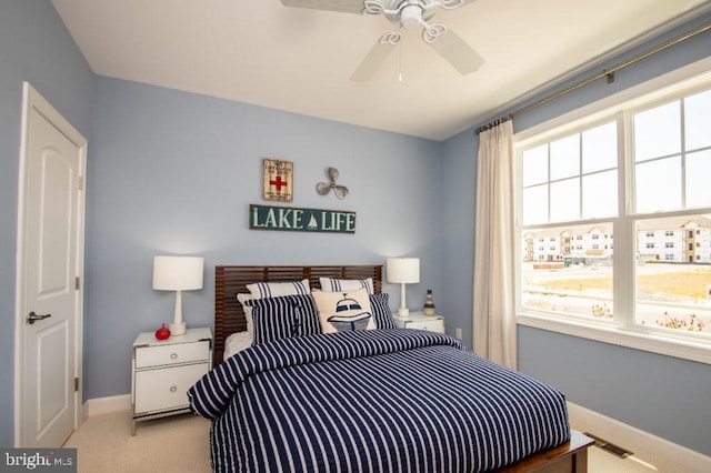 carpeted bedroom featuring multiple windows and ceiling fan