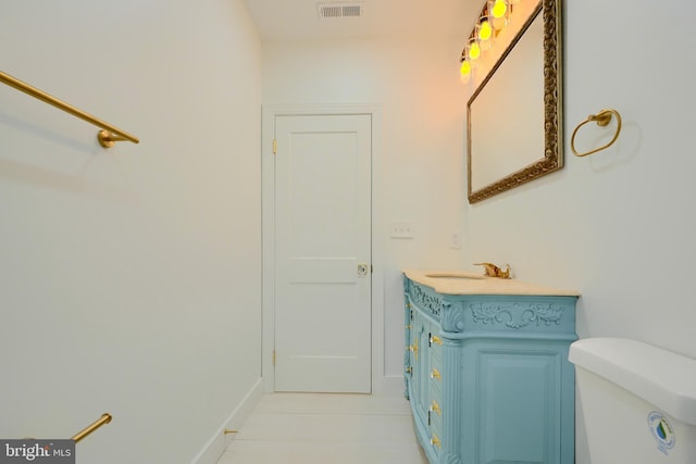 bathroom featuring tile patterned flooring, vanity, and toilet