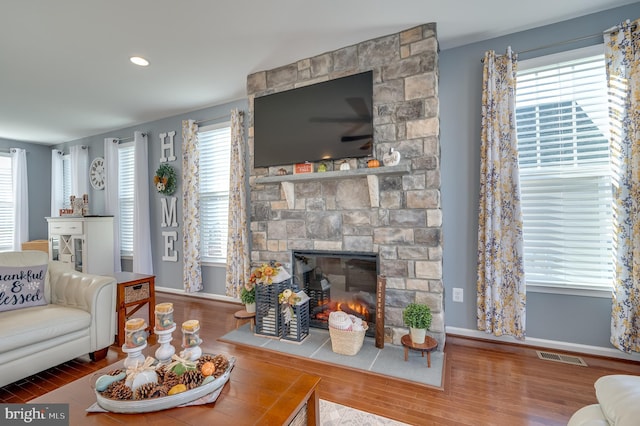 living room with hardwood / wood-style floors, a healthy amount of sunlight, and a fireplace