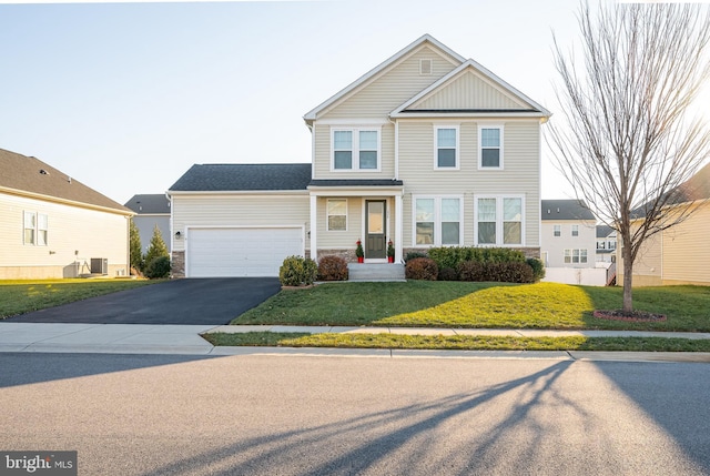 view of front of home with a front yard and a garage