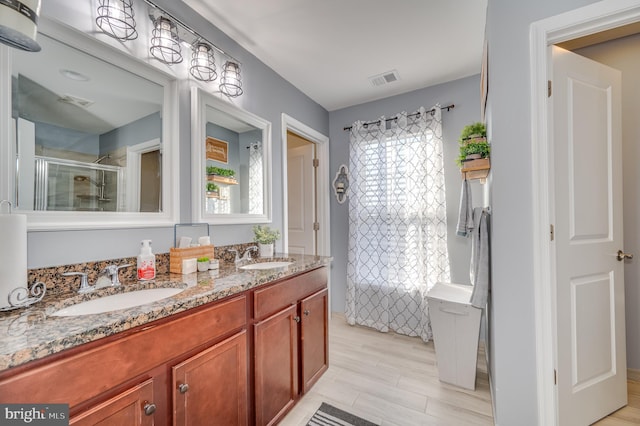 bathroom with hardwood / wood-style floors, vanity, and a healthy amount of sunlight