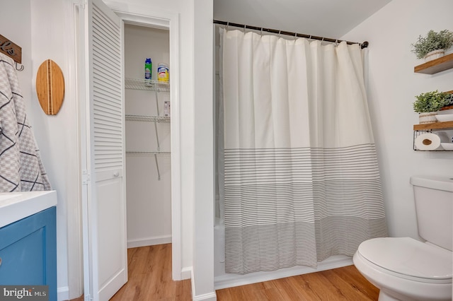 full bathroom with vanity, hardwood / wood-style flooring, toilet, and shower / tub combo with curtain