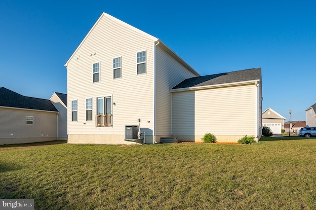 back of house featuring central AC and a yard