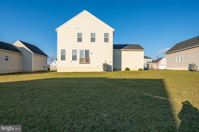 rear view of property featuring a lawn and central AC unit