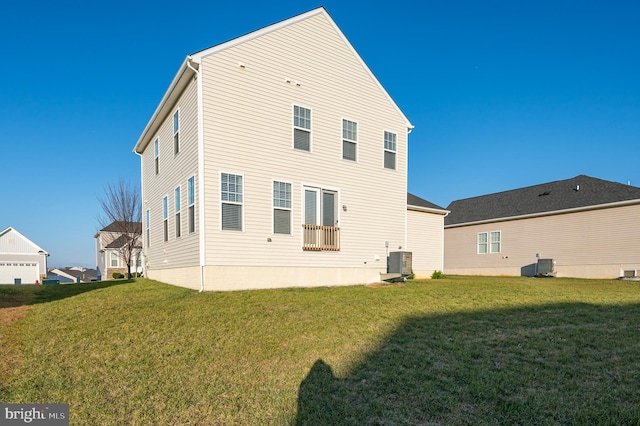 rear view of house featuring central AC unit and a lawn