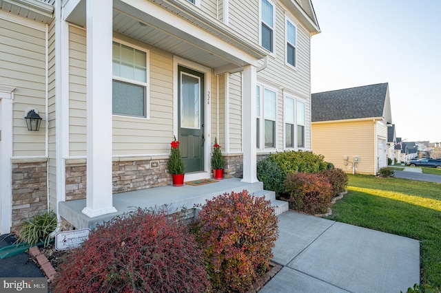 property entrance featuring a porch and a yard