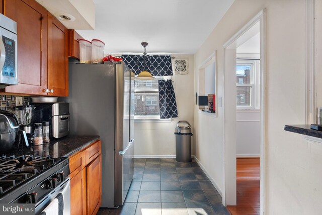 102 W Walnut Park Dr, Philadelphia, PA 19120 - kitchen with stainless steel appliances, brown cabinetry, and decorative backsplash
