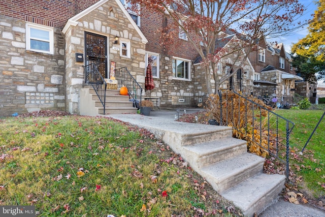 entrance to property with a lawn