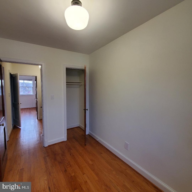 unfurnished bedroom featuring a closet and hardwood / wood-style floors