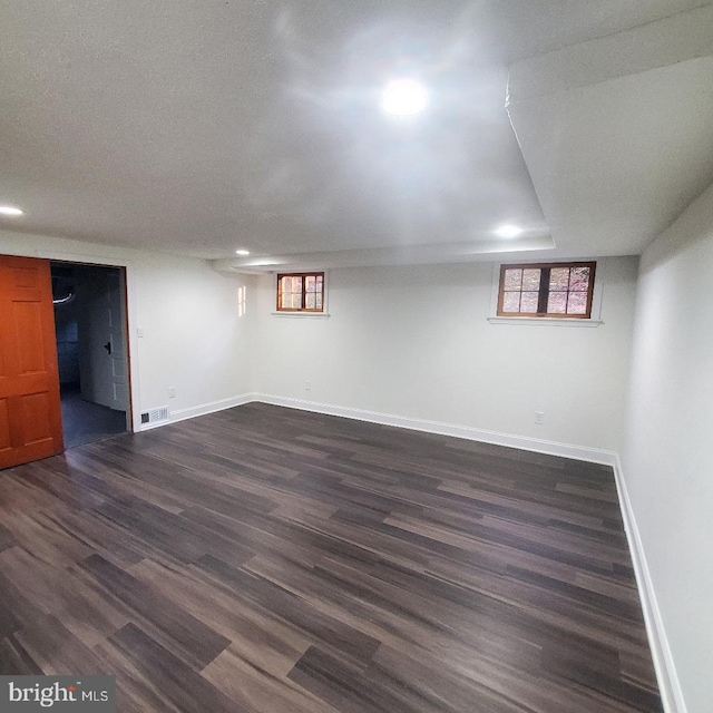 basement with dark hardwood / wood-style flooring