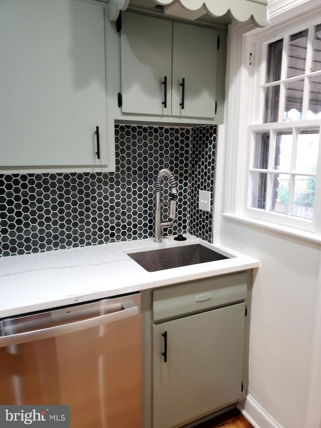 kitchen with tasteful backsplash, sink, and stainless steel dishwasher