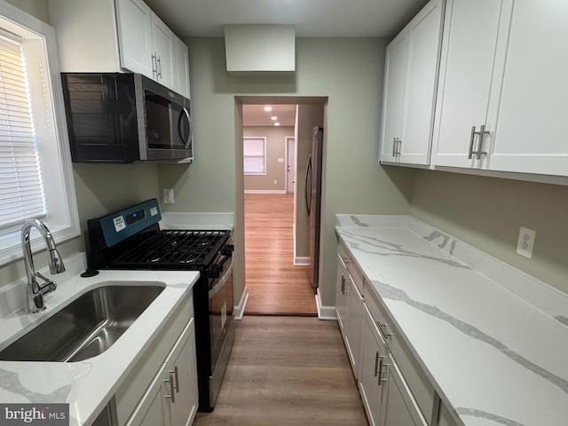 kitchen featuring white cabinetry, a healthy amount of sunlight, sink, and stainless steel appliances