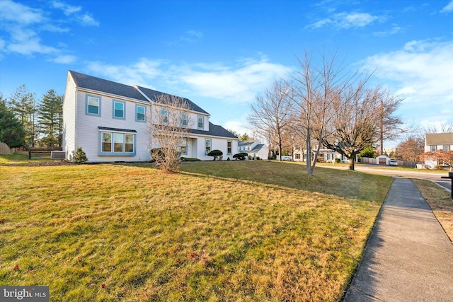 view of front of property with a front yard and cooling unit