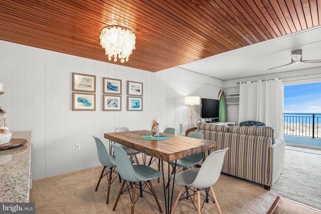 carpeted dining room with a chandelier, wood walls, and wood ceiling