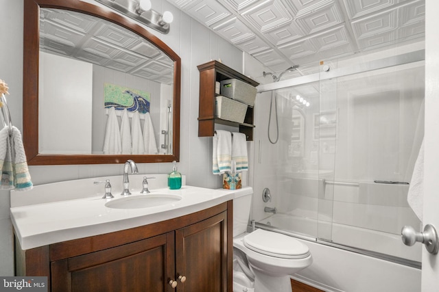 full bathroom with vanity, enclosed tub / shower combo, and toilet