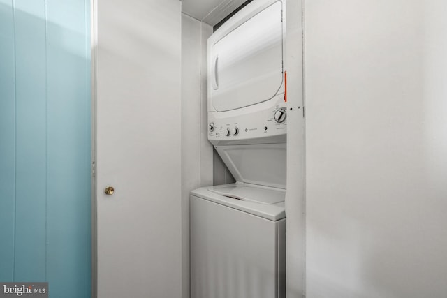 clothes washing area featuring stacked washer and dryer