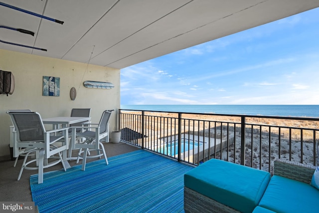 balcony featuring a water view and a view of the beach