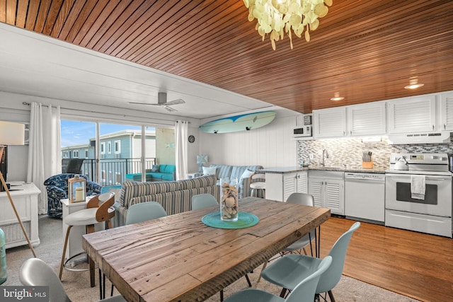 dining space featuring wooden ceiling, sink, light hardwood / wood-style floors, and ceiling fan with notable chandelier