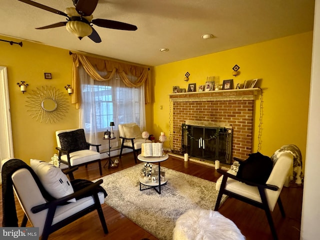 sitting room featuring a brick fireplace, ceiling fan, and hardwood / wood-style flooring