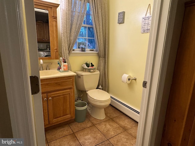 bathroom with tile patterned flooring, vanity, toilet, and a baseboard heating unit