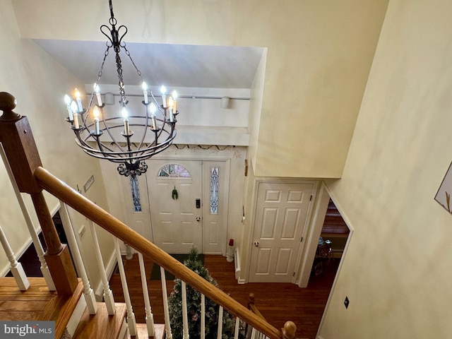 stairway featuring a chandelier and wood-type flooring