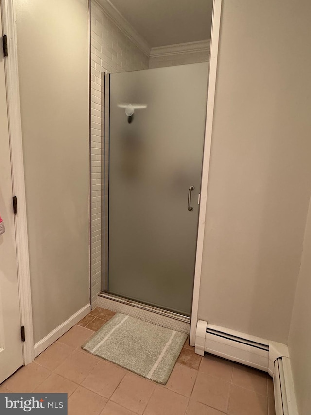 bathroom with crown molding, a shower with door, and a baseboard heating unit