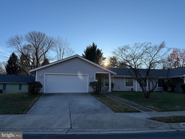 single story home featuring a lawn and a garage