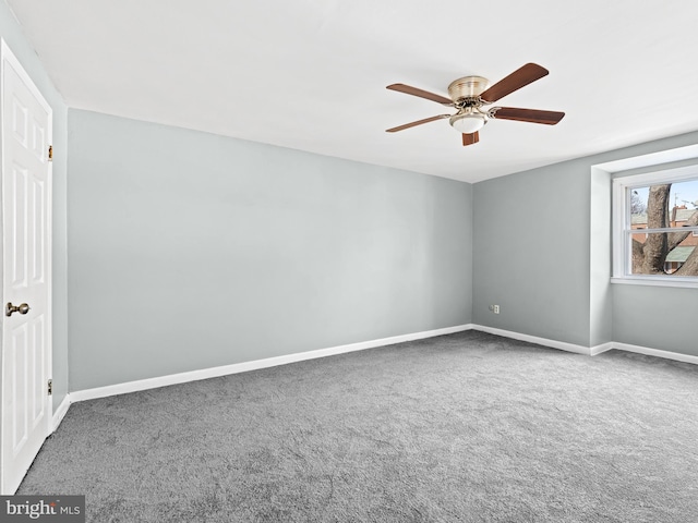 carpeted spare room with ceiling fan