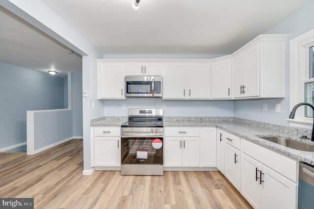 kitchen featuring sink, white cabinets, and appliances with stainless steel finishes