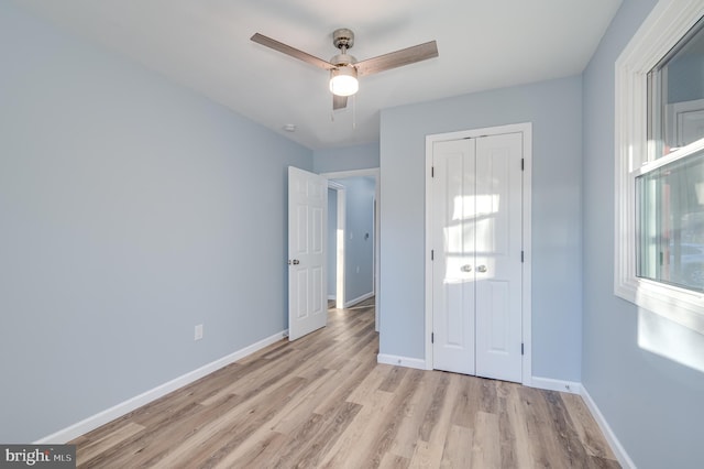 unfurnished bedroom featuring ceiling fan, light hardwood / wood-style floors, and a closet