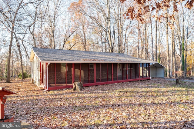 view of outdoor structure featuring a carport and a sunroom