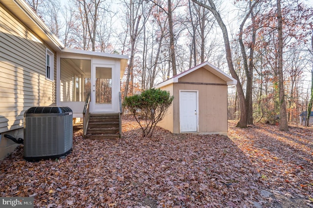 view of yard featuring a storage unit and central AC