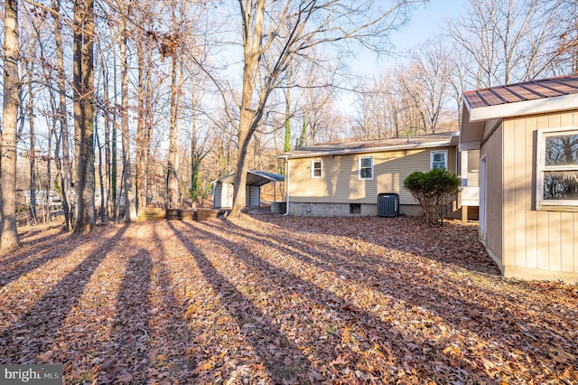 view of yard featuring a carport and central AC unit