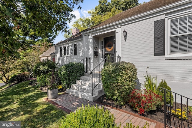 view of exterior entry with a lawn