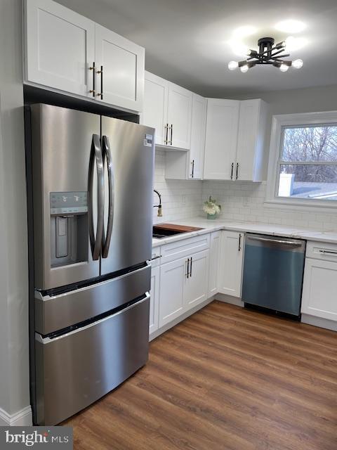 kitchen with ceiling fan, dark hardwood / wood-style floors, decorative backsplash, white cabinets, and appliances with stainless steel finishes