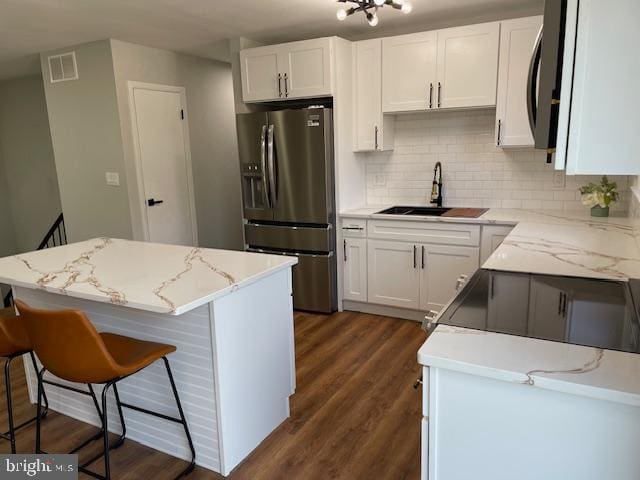 kitchen featuring a center island, white cabinets, sink, dark hardwood / wood-style flooring, and stainless steel appliances