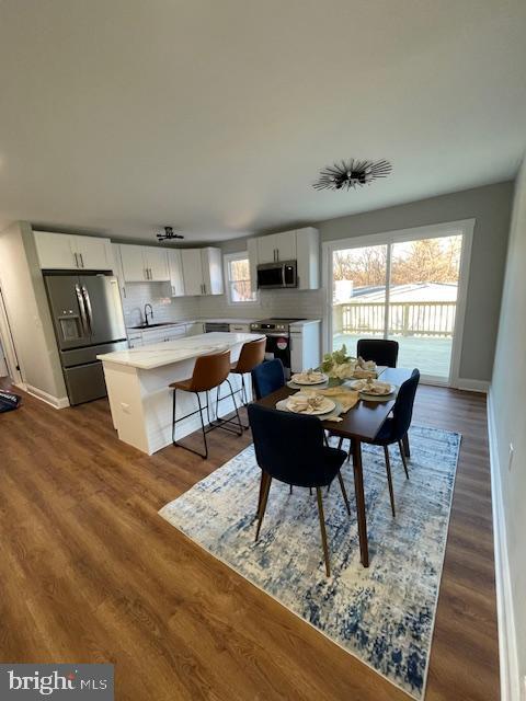 dining space with dark hardwood / wood-style flooring and sink